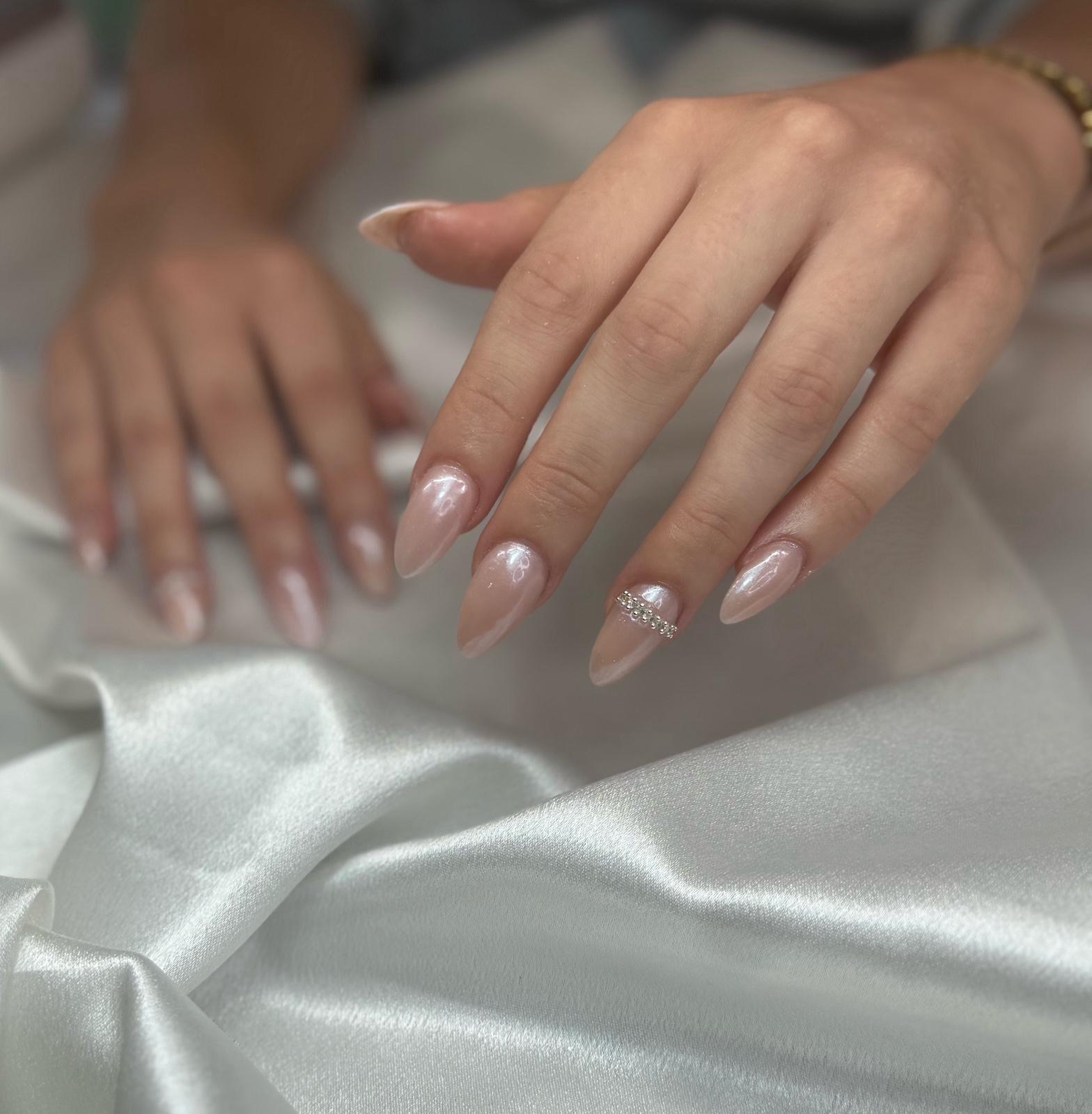 Soft pearl finish almond nails with a crystal detail